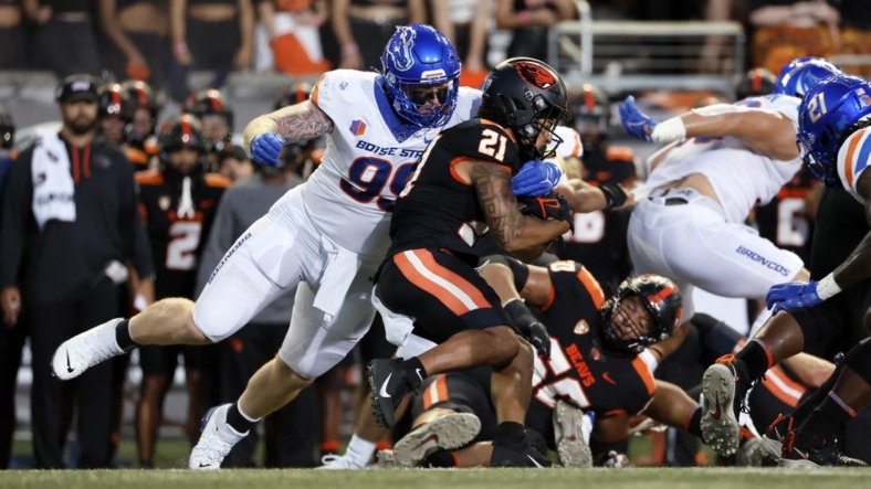 Sep 3, 2022; Corvallis, Oregon, USA; Oregon State Beavers running back Trey Lowe (21) is grabbed by Boise State Broncos defensive tackle Scott Matlock (99) during the first half at Reser Stadium. Mandatory Credit: Soobum Im-USA TODAY Sports