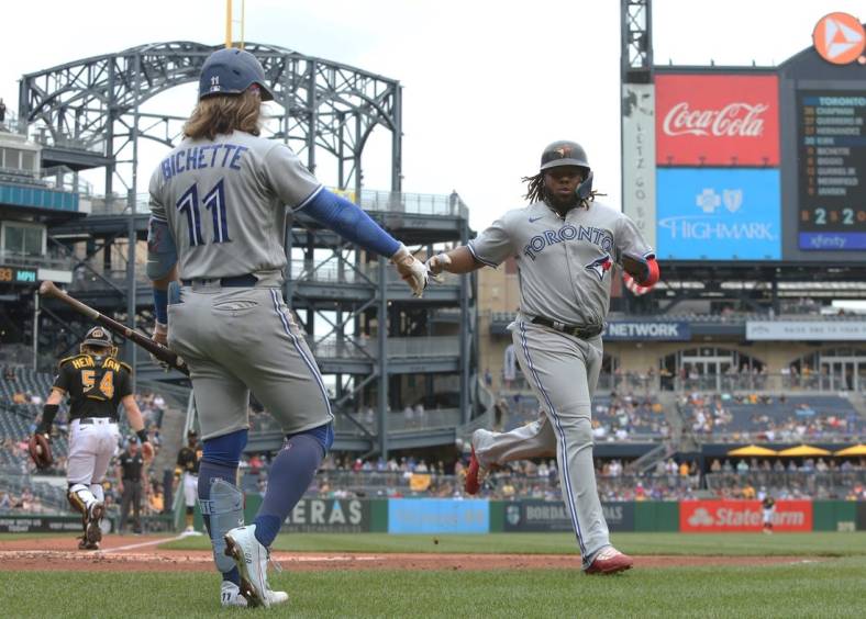 Sep 4, 2022; Pittsburgh, Pennsylvania, USA;  Toronto Blue Jays shortstop Bo Bichette (11) congratulates first baseman Vladimir Guerrero Jr. (right) after Guerrero scored a run against the Pittsburgh Pirates during the third inning at PNC Park. Mandatory Credit: Charles LeClaire-USA TODAY Sports