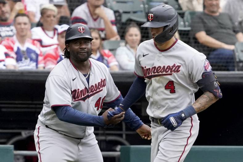 Sep 4, 2022; Chicago, Illinois, USA; Minnesota Twins shortstop Carlos Correa (4) is greeted by third base coach Tommy Watkins (40) after hitting a two-run home run against the Chicago White Sox during the fifth inning at Guaranteed Rate Field. Mandatory Credit: David Banks-USA TODAY Sports