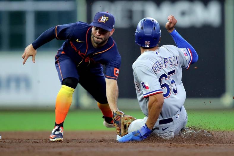 Sep 5, 2022; Houston, Texas, USA; Houston Astros second baseman Jose Altuve (27) tags out Texas Rangers left fielder Bubby Thompson (65) on a stolen base attempt during the third inning at Minute Maid Park. Mandatory Credit: Erik Williams-USA TODAY Sports