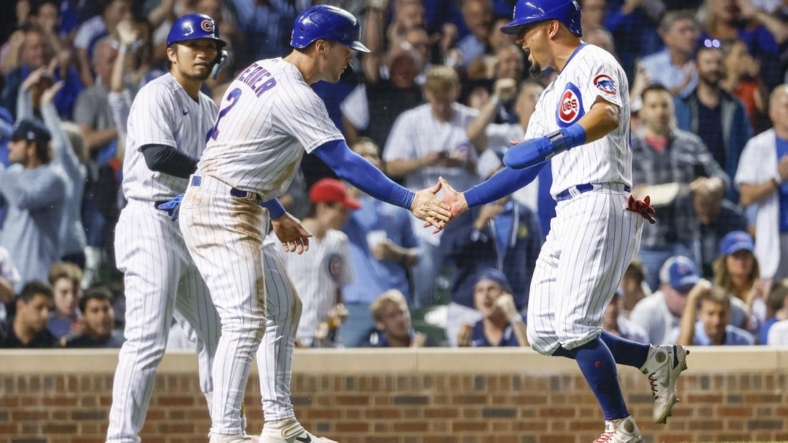 Sep 6, 2022; Chicago, Illinois, USA; Chicago Cubs shortstop Nico Hoerner (2) and center fielder Rafael Ortega (66) celebrate after they both scored against the Cincinnati Reds during the sixth inning at Wrigley Field. Mandatory Credit: Kamil Krzaczynski-USA TODAY Sports