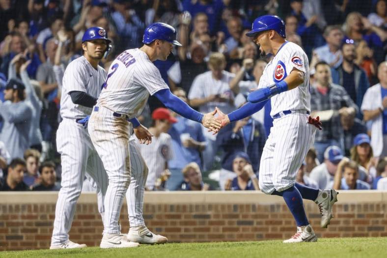 Sep 6, 2022; Chicago, Illinois, USA; Chicago Cubs shortstop Nico Hoerner (2) and center fielder Rafael Ortega (66) celebrate after they both scored against the Cincinnati Reds during the sixth inning at Wrigley Field. Mandatory Credit: Kamil Krzaczynski-USA TODAY Sports