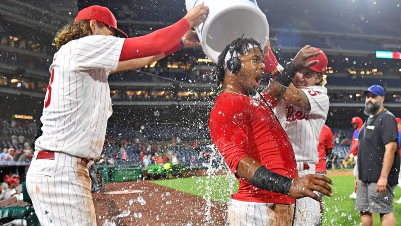 Sep 6, 2022; Philadelphia, Pennsylvania, USA;  Philadelphia Phillies second baseman Jean Segura (2) has water dumped on by third baseman Alec Bohm (28) and shortstop Bryson Stott (5)  after hitting a walk-off RBU single during the ninth inning against the Miami Marlins at Citizens Bank Park. Mandatory Credit: Eric Hartline-USA TODAY Sports