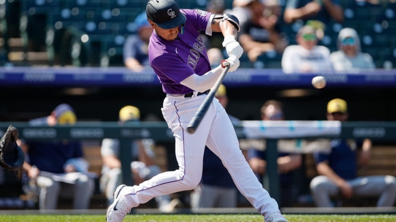 Sep 7, 2022; Denver, Colorado, USA; Colorado Rockies shortstop Alan Trejo (13) hits a two run home run in the second inning against the Milwaukee Brewers at Coors Field. Mandatory Credit: Isaiah J. Downing-USA TODAY Sports
