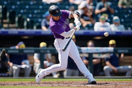 Sep 7, 2022; Denver, Colorado, USA; Colorado Rockies shortstop Alan Trejo (13) hits a two run home run in the second inning against the Milwaukee Brewers at Coors Field. Mandatory Credit: Isaiah J. Downing-USA TODAY Sports