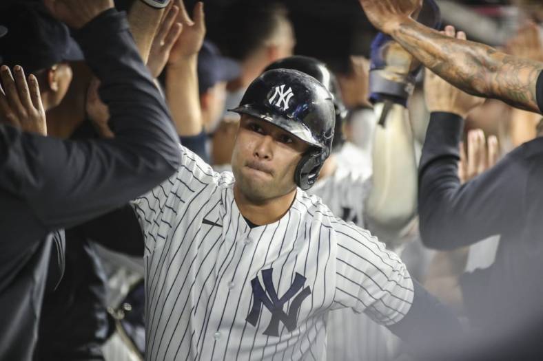 Sep 7, 2022; Bronx, New York, USA;  New York Yankees third baseman Isiah Kiner-Falefa (12) is greeted in the dugout after hitting a grand slam home run in the fourth inning against the Minnesota Twins at Yankee Stadium. Mandatory Credit: Wendell Cruz-USA TODAY Sports