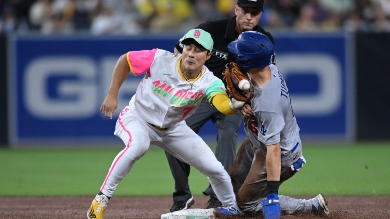 Sep 9, 2022; San Diego, California, USA; Los Angeles Dodgers shortstop Trea Turner (right) steals second base as the throws gets away from San Diego Padres shortstop Ha-Seong Kim (7) and hits Turner during the fifth inning at Petco Park. Mandatory Credit: Orlando Ramirez-USA TODAY Sports