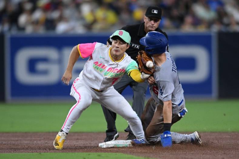 Sep 9, 2022; San Diego, California, USA; Los Angeles Dodgers shortstop Trea Turner (right) steals second base as the throws gets away from San Diego Padres shortstop Ha-Seong Kim (7) and hits Turner during the fifth inning at Petco Park. Mandatory Credit: Orlando Ramirez-USA TODAY Sports