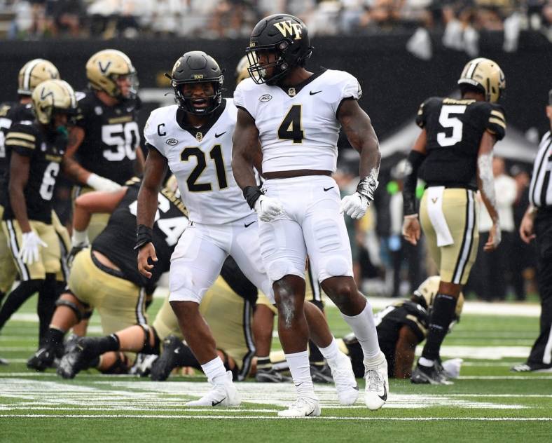 Sep 10, 2022; Nashville, Tennessee, USA; Wake Forest Demon Deacons defensive lineman Jacorey Johns (4) and linebacker Chase Jones (21) celebrate after a defensive stop during the first half against the Vanderbilt Commodores at FirstBank Stadium. Mandatory Credit: Christopher Hanewinckel-USA TODAY Sports