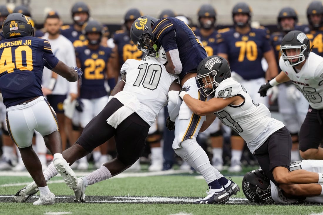 Sep 10, 2022; Berkeley, California, USA; UNLV Rebels linebacker Fred Thompkins (10) hits California Golden Bears wide receiver Jeremiah Hunter (3) as defensive back Davone Walden Jr. (37) tackles during the second quarter at FTX Field at California Memorial Stadium. Mandatory Credit: Darren Yamashita-USA TODAY Sports