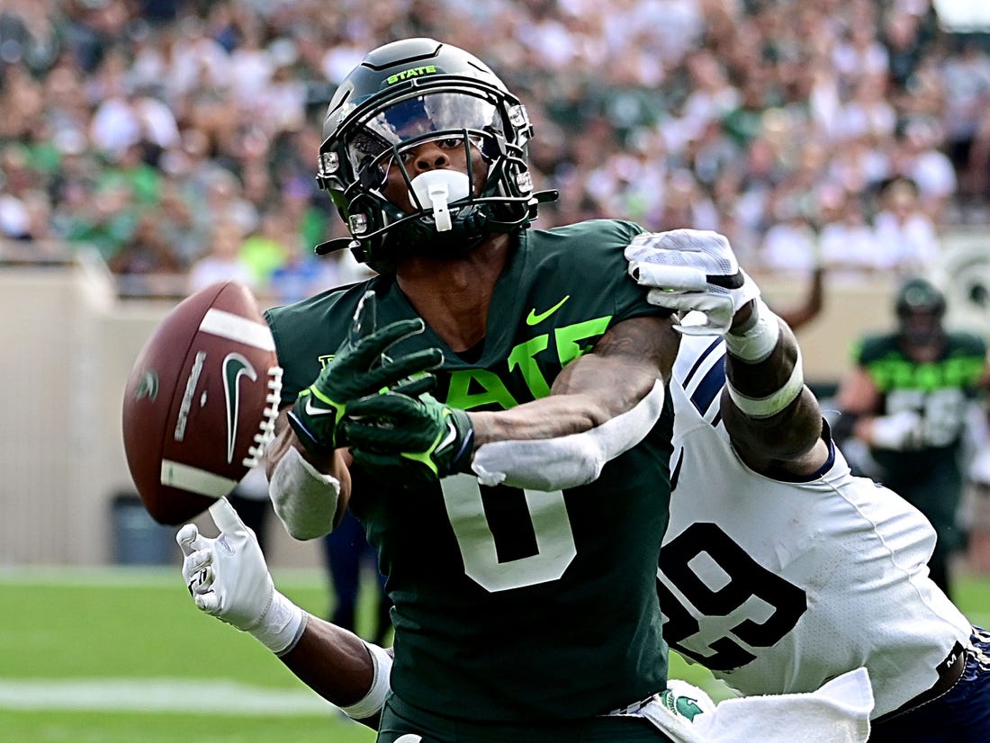 Sep 10, 2022; East Lansing, Michigan, USA;   Michigan State Spartans wide receiver Keon Coleman (0) can not hold onto the ball after being hit by Akron Zips cornerback Jalen Hooks (29). Mandatory Credit: Dale Young-USA TODAY Sports