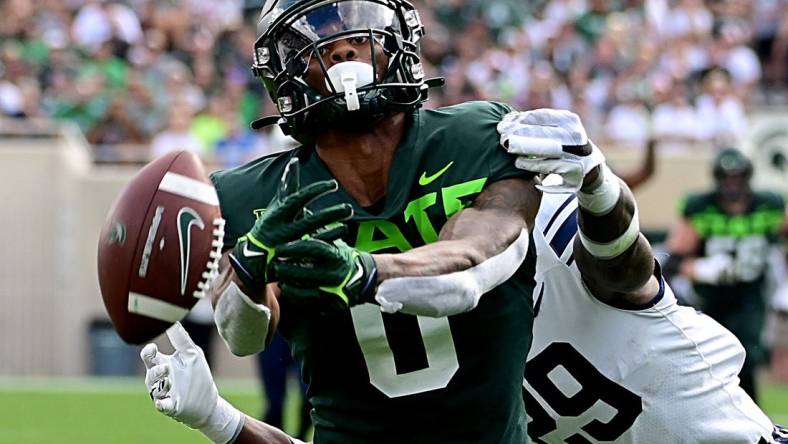 Sep 10, 2022; East Lansing, Michigan, USA;   Michigan State Spartans wide receiver Keon Coleman (0) can not hold onto the ball after being hit by Akron Zips cornerback Jalen Hooks (29). Mandatory Credit: Dale Young-USA TODAY Sports