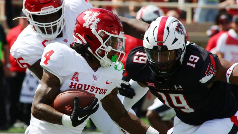 Sep 10, 2022; Lubbock, Texas, USA;  Houston Cougars running back Ta   Zawn Henry (4) rushes against Texas Tech Red Raiders defensive back Tyree Wilson (19) in the first half at Jones AT&T Stadium and Cody Campbell Field. Mandatory Credit: Michael C. Johnson-USA TODAY Sports