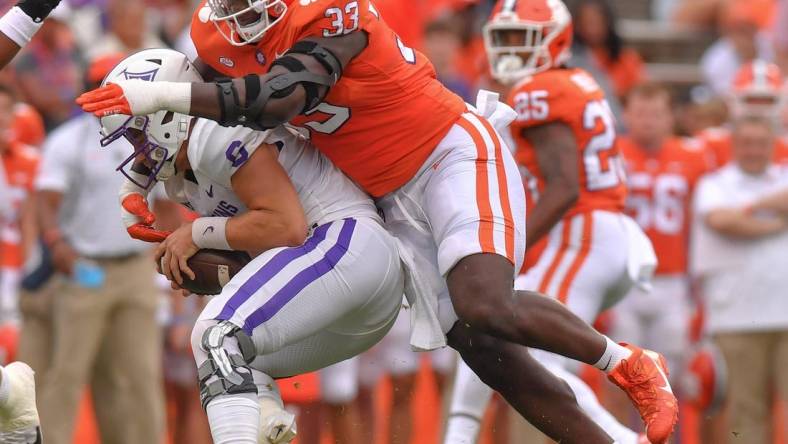 Sep 10, 2022; Clemson, South Carolina, USA;  Clemson Tigers defensive tackle Ruke Orhorhoro (33) tackles Furman Paladins quarterback Tyler Huff (6) during the first quarter at Memorial Stadium. Mandatory Credit: Ken Ruinard-USA TODAY Sports