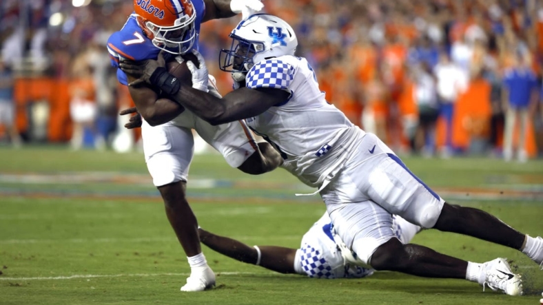 Sep 10, 2022; Gainesville, Florida, USA; Florida Gators running back Trevor Etienne (7) runs with the ball as Kentucky Wildcats defensive tackle Octavious Oxendine (8) tackles  during the first half at Ben Hill Griffin Stadium. Mandatory Credit: Kim Klement-USA TODAY Sports
