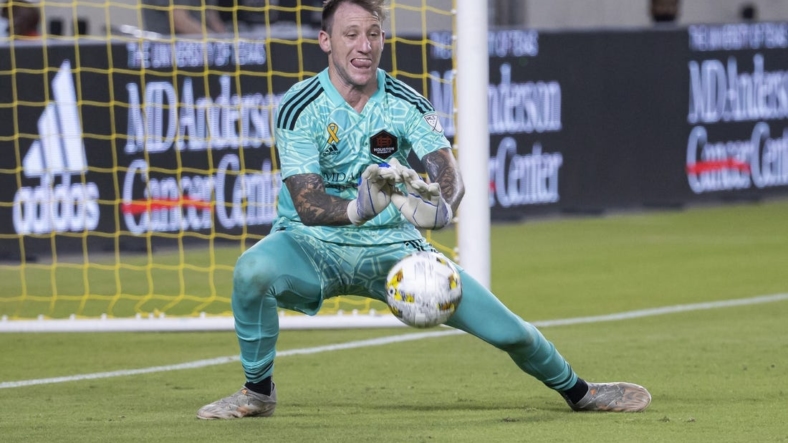 Sep 10, 2022; Houston, Texas, USA; Houston Dynamo FC goalkeeper Steve Clark (12) defects a shot during stoppage time in the second half against the Sporting Kansas City at PNC Stadium. Mandatory Credit: Troy Taormina-USA TODAY Sports