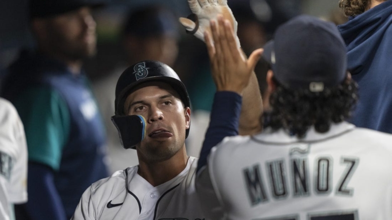 Sep 10, 2022; Seattle, Washington, USA; Seattle Mariners second baseman Adam Frazier (26) is congrulated by teammates in the dugout after scoring a run during the seventh inning against the Atlanta Braves at T-Mobile Park. Mandatory Credit: Stephen Brashear-USA TODAY Sports
