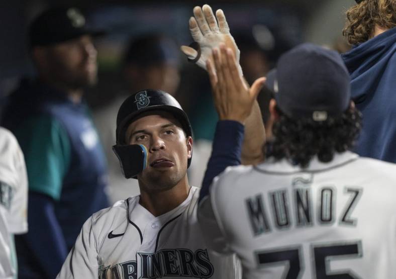 Sep 10, 2022; Seattle, Washington, USA; Seattle Mariners second baseman Adam Frazier (26) is congrulated by teammates in the dugout after scoring a run during the seventh inning against the Atlanta Braves at T-Mobile Park. Mandatory Credit: Stephen Brashear-USA TODAY Sports