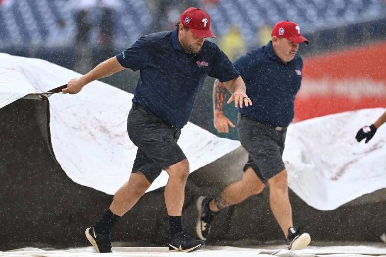 Sep 11, 2022; Philadelphia, Pennsylvania, USA; Phillies Grounds Crew cover the field during a rain delay during the game between the Philadelphia Phillies and Washington Nationals at Citizens Bank Park. Mandatory Credit: Kyle Ross-USA TODAY Sports