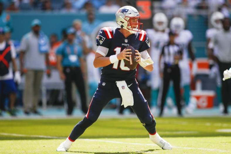 Sep 11, 2022; Miami Gardens, Florida, USA; New England Patriots quarterback Mac Jones (10) watches from the field prior attempting a pass during the fourth quarter against the Miami Dolphins at Hard Rock Stadium. Mandatory Credit: Sam Navarro-USA TODAY Sports