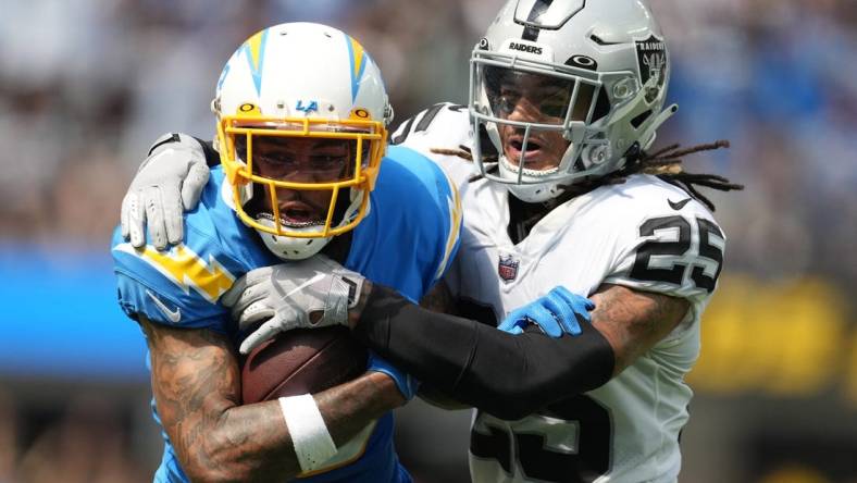 Sep 11, 2022; Inglewood, California, USA; Los Angeles Chargers wide receiver Keenan Allen (13) tries to break free from the grasp of Las Vegas Raiders safety Tre'von Moehrig (25) in the first half at SoFi Stadium. Mandatory Credit: Kirby Lee-USA TODAY Sports