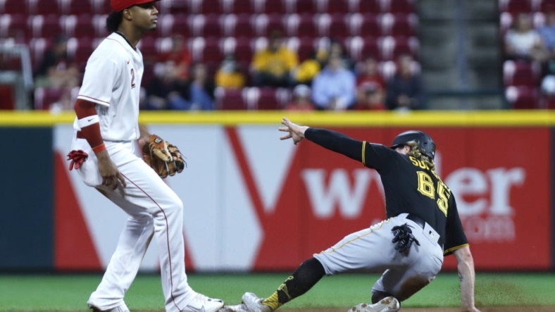 Sep 12, 2022; Cincinnati, Ohio, USA; Pittsburgh Pirates right fielder Jack Suwinski (65) slides safely second base after a bunt single against Cincinnati Reds shortstop Jose Barrero (2) during the fourth inning at Great American Ball Park. Mandatory Credit: David Kohl-USA TODAY Sports