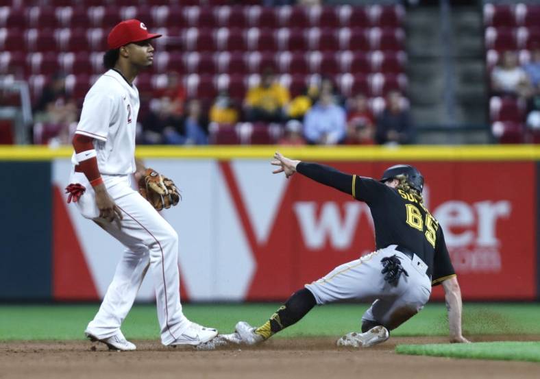Sep 12, 2022; Cincinnati, Ohio, USA; Pittsburgh Pirates right fielder Jack Suwinski (65) slides safely second base after a bunt single against Cincinnati Reds shortstop Jose Barrero (2) during the fourth inning at Great American Ball Park. Mandatory Credit: David Kohl-USA TODAY Sports