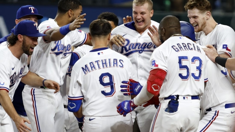 Sep 13, 2022; Arlington, Texas, USA; Texas Rangers first baseman Mark Mathias (9) is congratulated by his teammates after he hit the game-winning home run against the Oakland Athletics in the bottom of the ninth inning at Globe Life Field. Mandatory Credit: Tim Heitman-USA TODAY Sports