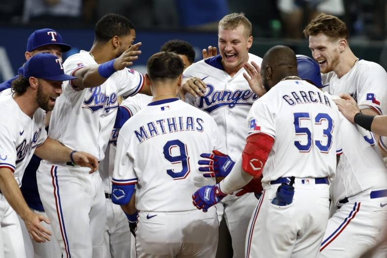 Sep 13, 2022; Arlington, Texas, USA; Texas Rangers first baseman Mark Mathias (9) is congratulated by his teammates after he hit the game-winning home run against the Oakland Athletics in the bottom of the ninth inning at Globe Life Field. Mandatory Credit: Tim Heitman-USA TODAY Sports