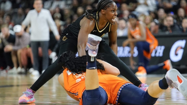 Sep 13, 2022; Las Vegas, Nevada, USA; Las Vegas Aces guard Chelsea Gray (12) reacts to being fouled by Connecticut Sun forward Brionna Jones (42) during the second quarter in game two of the WNBA Finals at Michelob Ultra Arena. Mandatory Credit: Lucas Peltier-USA TODAY Sports
