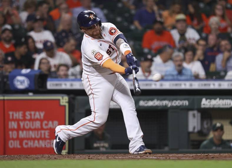 Sep 15, 2022; Houston, Texas, USA; Houston Astros catcher Christian Vazquez (21) hits an RBI double during the fourth inning against the Oakland Athletics at Minute Maid Park. Mandatory Credit: Troy Taormina-USA TODAY Sports