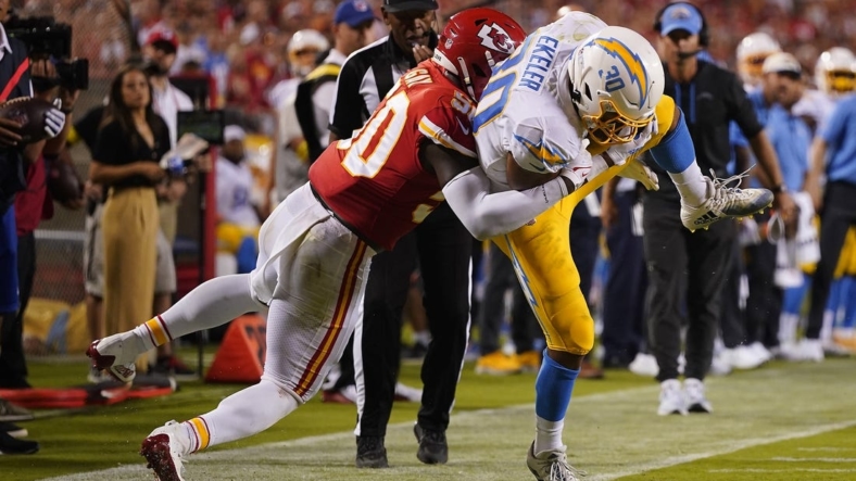 Sep 15, 2022; Kansas City, Missouri, USA; Los Angeles Chargers running back Austin Ekeler (30) is brought down by Kansas City Chiefs linebacker Willie Gay (50) during the second half at GEHA Field at Arrowhead Stadium. Mandatory Credit: Jay Biggerstaff-USA TODAY Sports