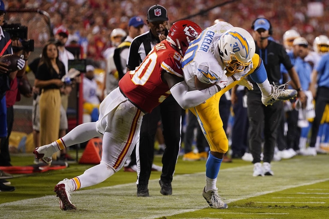 Sep 15, 2022; Kansas City, Missouri, USA; Los Angeles Chargers running back Austin Ekeler (30) is brought down by Kansas City Chiefs linebacker Willie Gay (50) during the second half at GEHA Field at Arrowhead Stadium. Mandatory Credit: Jay Biggerstaff-USA TODAY Sports