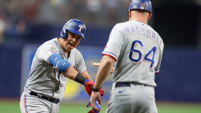 Sep 16, 2022; St. Petersburg, Florida, USA;  Texas Rangers first baseman Nathaniel Lowe (30) is congratulated by third base coach Corey Ragsdale (64) after hitting a two-run home run against the Tampa Bay Rays in the third inning at Tropicana Field. Mandatory Credit: Nathan Ray Seebeck-USA TODAY Sports