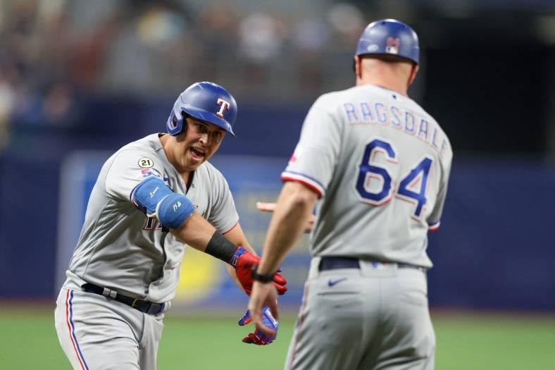 Sep 16, 2022; St. Petersburg, Florida, USA;  Texas Rangers first baseman Nathaniel Lowe (30) is congratulated by third base coach Corey Ragsdale (64) after hitting a two-run home run against the Tampa Bay Rays in the third inning at Tropicana Field. Mandatory Credit: Nathan Ray Seebeck-USA TODAY Sports