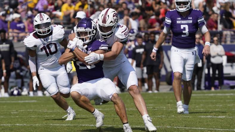 Sep 17, 2022; Evanston, Illinois, USA; Southern Illinois Salukis linebacker Branson Combs (12) tackles Northwestern Wildcats running back Evan Hull (26) during the first half at Ryan Field. Mandatory Credit: David Banks-USA TODAY Sports