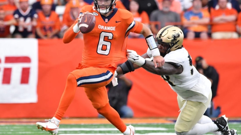 Sep 17, 2022; Syracuse, New York, USA; Syracuse Orange quarterback Garrett Shrader (6) avoids a tackle by Purdue Boilermakers defensive tackle Branson Deen (58) in the third quarter at JMA Wireless Dome. Mandatory Credit: Mark Konezny-USA TODAY Sports