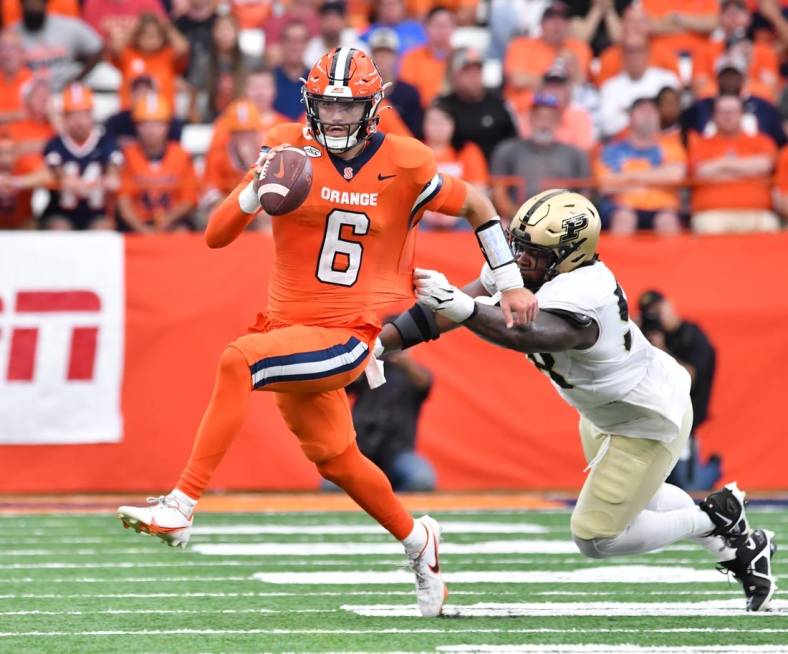 Sep 17, 2022; Syracuse, New York, USA; Syracuse Orange quarterback Garrett Shrader (6) avoids a tackle by Purdue Boilermakers defensive tackle Branson Deen (58) in the third quarter at JMA Wireless Dome. Mandatory Credit: Mark Konezny-USA TODAY Sports