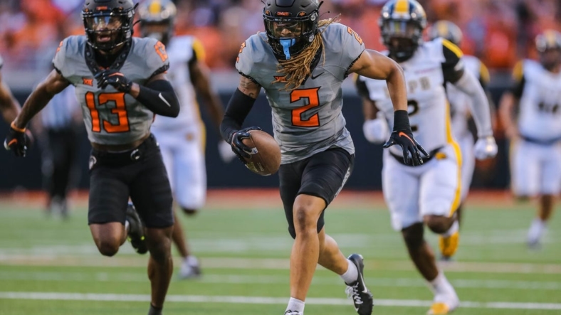 Sep 17, 2022; Stillwater, Oklahoma, USA; Oklahoma State Cowboys cornerback Korie Black (2) picks up a blocked kick and returns it for a touchdown against the Arkansas-Pine Bluff Golden Lions in the first half at Boone Pickens Stadium. Mandatory Credit: Nathan J. Fish-USA TODAY Sports