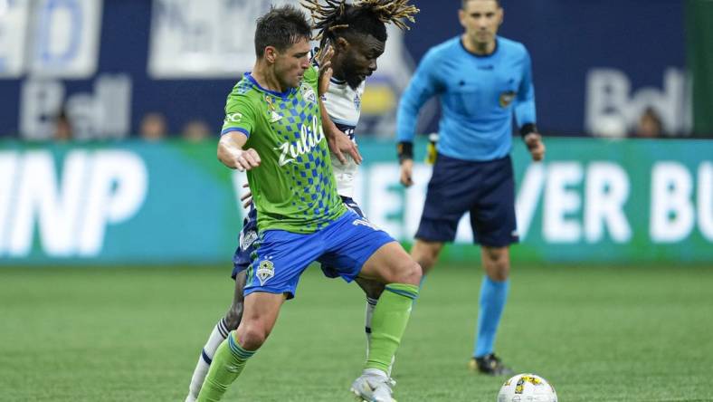 Sep 17, 2022; Vancouver, British Columbia, CAN; Seattle Sounders midfielder Nicolas Lodeiro (10) and Vancouver Whitecaps midfielder Leonard Owusu (17) battle for the ball in the second half at BC Place. Mandatory Credit: Bob Frid-USA TODAY Sports