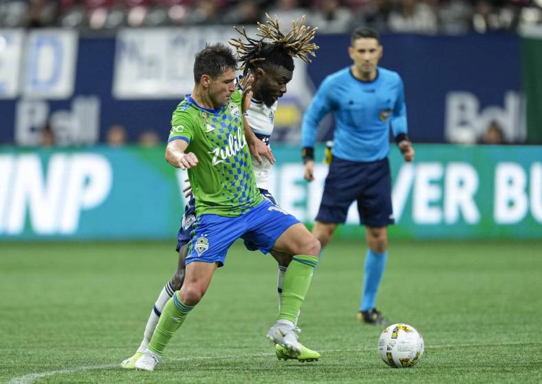 Sep 17, 2022; Vancouver, British Columbia, CAN; Seattle Sounders midfielder Nicolas Lodeiro (10) and Vancouver Whitecaps midfielder Leonard Owusu (17) battle for the ball in the second half at BC Place. Mandatory Credit: Bob Frid-USA TODAY Sports