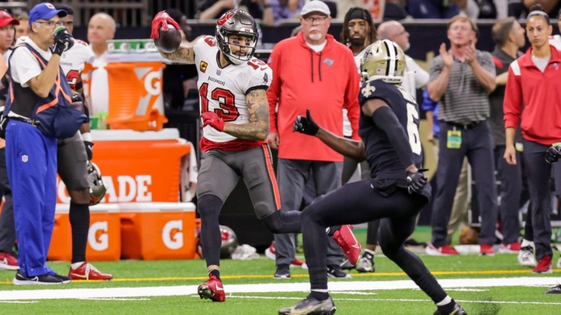 Sep 18, 2022; New Orleans, Louisiana, USA;  Tampa Bay Buccaneers wide receiver Mike Evans (13) is shoved out of bounds by New Orleans Saints safety Justin Evans (30) and safety Marcus Maye (6) during the first half at Caesars Superdome. Mandatory Credit: Stephen Lew-USA TODAY Sports
