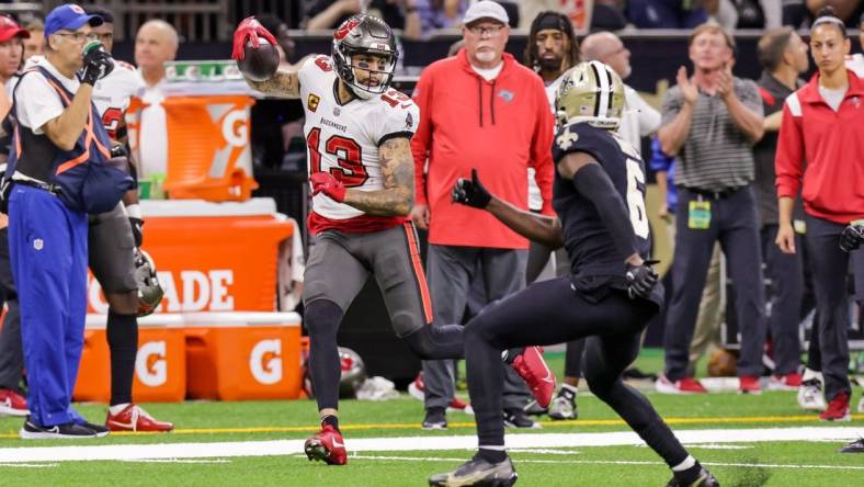 Sep 18, 2022; New Orleans, Louisiana, USA;  Tampa Bay Buccaneers wide receiver Mike Evans (13) is shoved out of bounds by New Orleans Saints safety Justin Evans (30) and safety Marcus Maye (6) during the first half at Caesars Superdome. Mandatory Credit: Stephen Lew-USA TODAY Sports