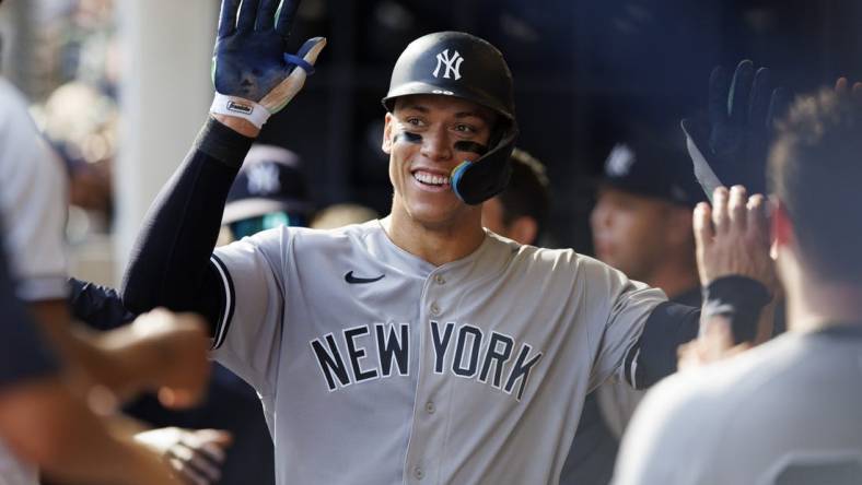 Sep 18, 2022; Milwaukee, Wisconsin, USA;  New York Yankees center fielder Aaron Judge (99) celebrates with teammates in the dugout after hitting a home run during the seventh inning against the Milwaukee Brewers at American Family Field. Mandatory Credit: Jeff Hanisch-USA TODAY Sports