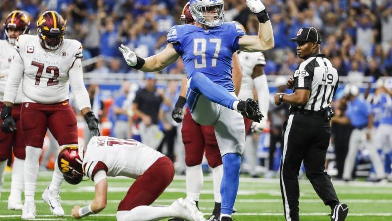 Sep 18, 2022; Detroit, Michigan, USA; Detroit Lions defensive end Aidan Hutchinson (97) celebrates a sack against Washington Commanders quarterback Carson Wentz (11) during the first half at Ford Field. Mandatory Credit: Junfu Han-USA TODAY Sports