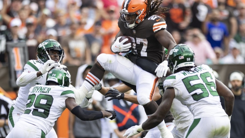 Sep 18, 2022; Cleveland, Ohio, USA; Cleveland Browns running back Kareem Hunt (27) leaps with the ball as he is tackled by New York Jets cornerback Sauce Gardner (1) and safety Lamarcus Joyner (29) along with linebacker Quincy Williams (56) during the fourth quarter at FirstEnergy Stadium. Mandatory Credit: Scott Galvin-USA TODAY Sports