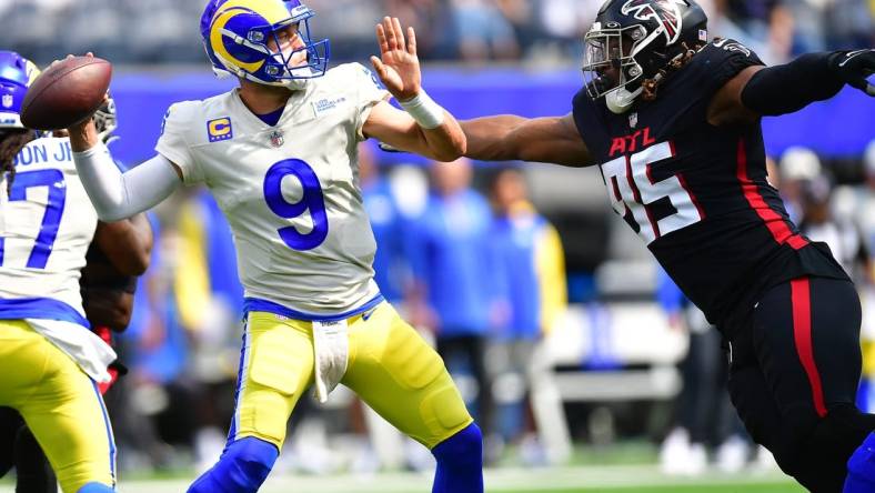 Sep 18, 2022; Inglewood, California, USA; Los Angeles Rams quarterback Matthew Stafford (9) throws under pressure from Atlanta Falcons defensive tackle Ta'Quon Graham (95) during the first half at SoFi Stadium. Mandatory Credit: Gary A. Vasquez-USA TODAY Sports