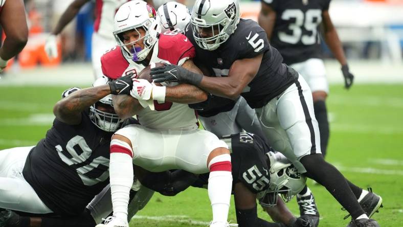 Sep 18, 2022; Paradise, Nevada, USA; Arizona Cardinals running back James Conner (6) is tackled by Las Vegas Raiders defensive tackle Johnathan Hankins (90) and Las Vegas Raiders linebacker Divine Deablo (5) during a game at Allegiant Stadium. Mandatory Credit: Stephen R. Sylvanie-USA TODAY Sports