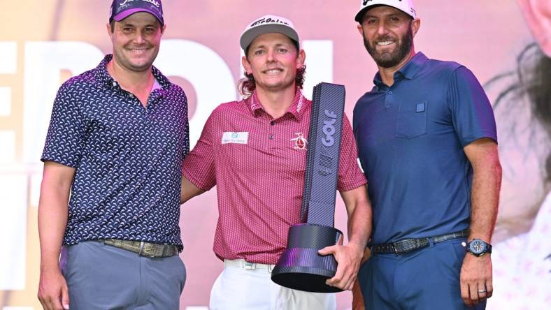 Sep 18, 2022; Chicago, Illinois, USA; Cameron Smith holds the winning trophy while posing with runner up Peter Uihlein, far left, and third place finisher Dustin Johnson after the final round of the Invitational Chicago LIV Golf tournament at Rich Harvest Farms. Mandatory Credit: Jamie Sabau-USA TODAY Sports