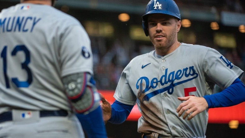 Sep 18, 2022; San Francisco, California, USA;  Los Angeles Dodgers first baseman Freddie Freeman (5) high fives third baseman Max Muncy (13) after scoring during the fourth inning against the San Francisco Giants at Oracle Park. Mandatory Credit: Ed Szczepanski-USA TODAY Sports